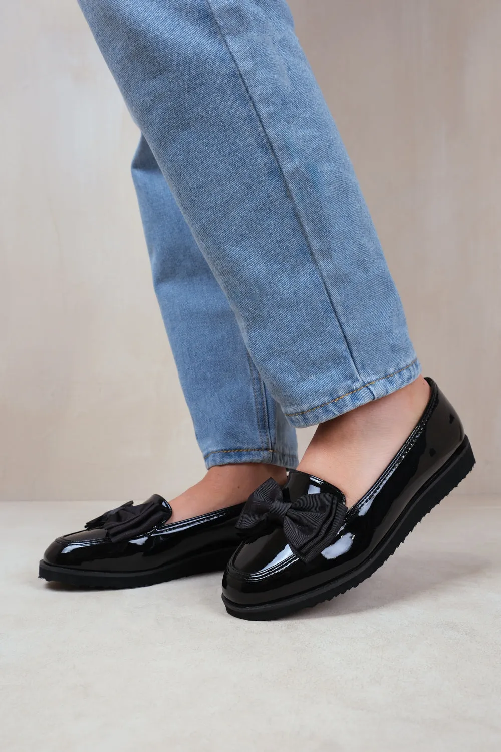 ALPHA WIDE FIT SLIP ON LOAFER SLIDER WITH BOW DETAIL IN BLACK PATENT FAUX LEATHER